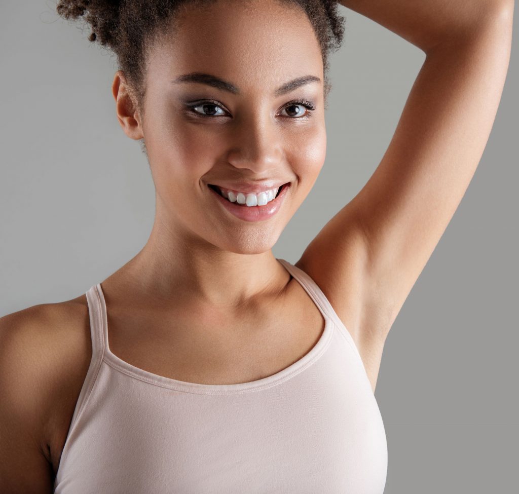 Pretty young woman showing off a hairless armpit